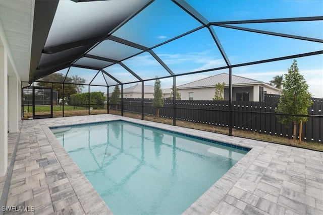 view of swimming pool with glass enclosure and a patio area