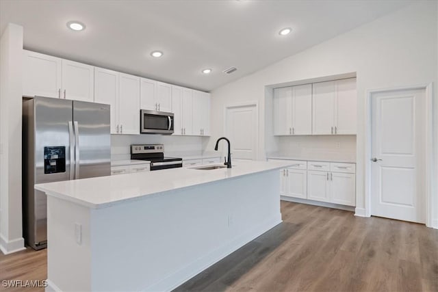 kitchen featuring white cabinetry, sink, a center island with sink, and appliances with stainless steel finishes