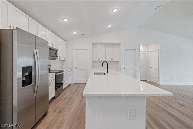 kitchen featuring an island with sink, appliances with stainless steel finishes, white cabinets, and light wood-type flooring