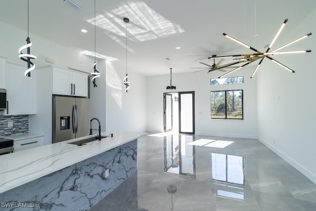 kitchen featuring stainless steel appliances, white cabinetry, hanging light fixtures, and sink