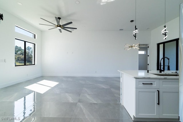 unfurnished living room featuring sink and ceiling fan