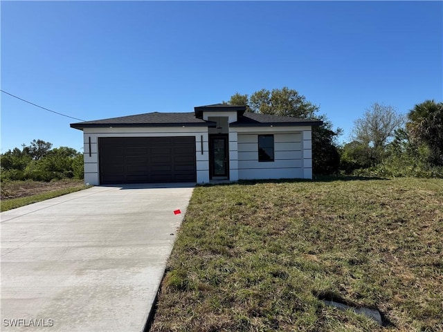 view of front of house with concrete driveway, an attached garage, and a front lawn