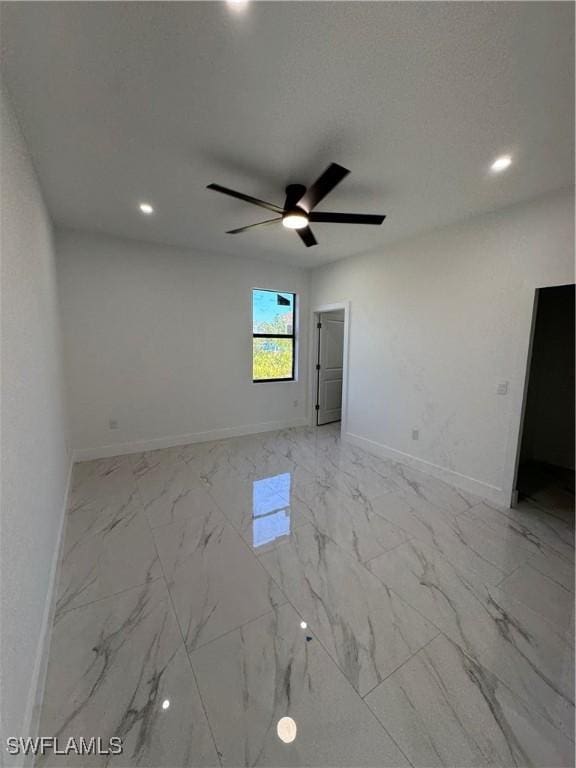 unfurnished room with a ceiling fan, recessed lighting, baseboards, and marble finish floor