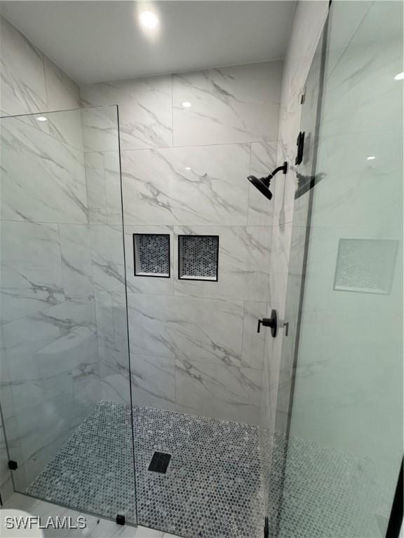 full bathroom with a marble finish shower