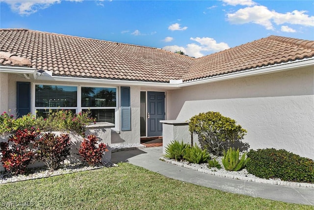 doorway to property with a lawn