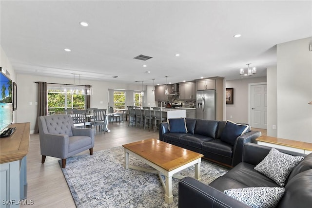 living room featuring an inviting chandelier and light hardwood / wood-style flooring