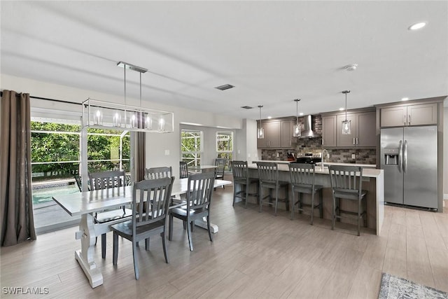 dining area featuring a notable chandelier and light hardwood / wood-style flooring