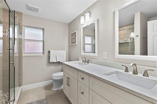 bathroom with vanity, toilet, a shower with door, and wood-type flooring