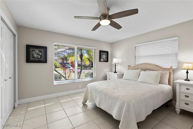 tiled bedroom featuring ceiling fan and a closet