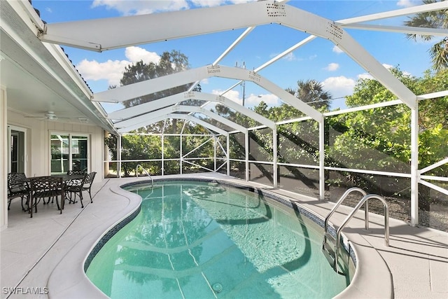 view of swimming pool featuring ceiling fan, a lanai, and a patio area