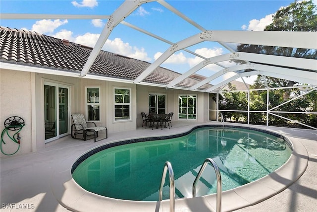 view of swimming pool featuring a lanai and a patio