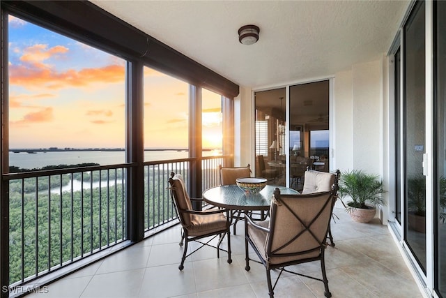 sunroom / solarium featuring a water view and a healthy amount of sunlight