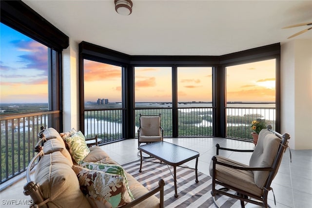 sunroom featuring a water view