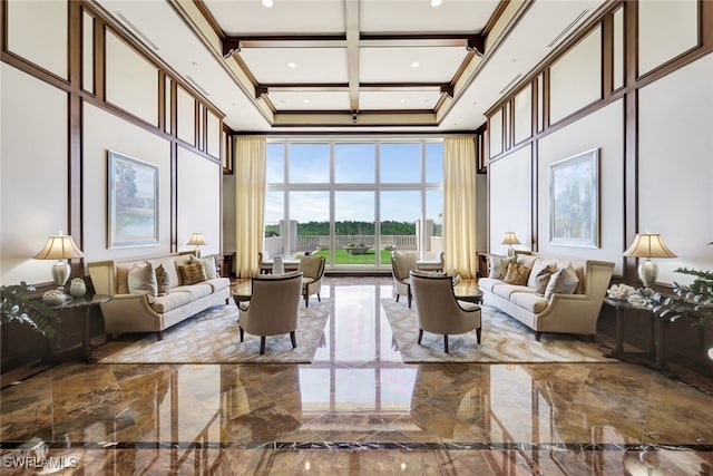 living area featuring coffered ceiling, marble finish floor, a towering ceiling, and crown molding