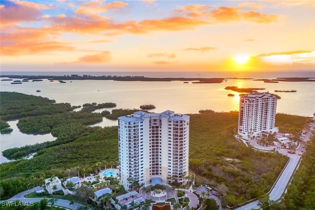 aerial view at dusk featuring a water view