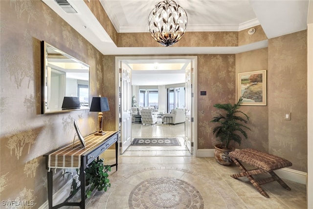 hall featuring visible vents, baseboards, and a notable chandelier