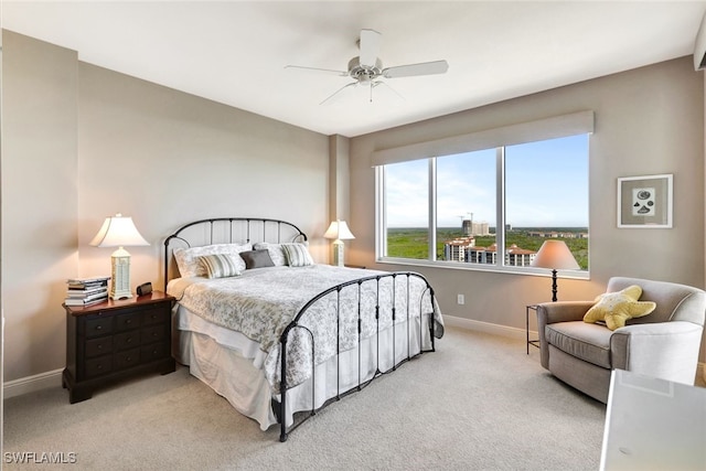 carpeted bedroom with a ceiling fan and baseboards