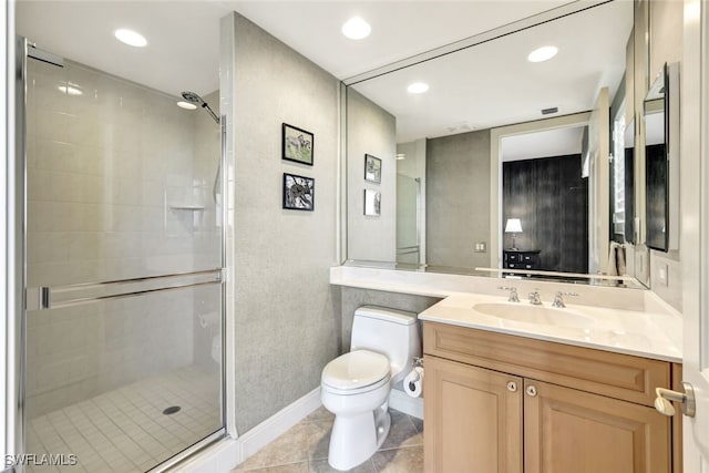 bathroom featuring tile patterned floors, toilet, a shower with shower door, and vanity