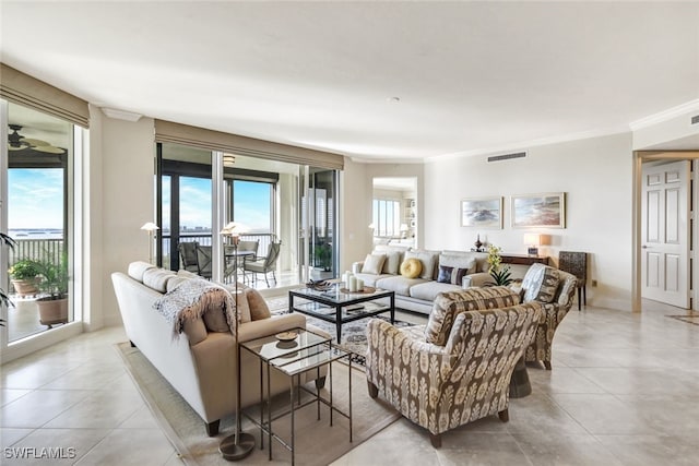 living area featuring light tile patterned flooring, baseboards, visible vents, and ornamental molding