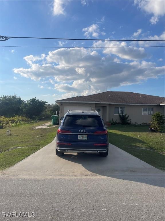 view of front of property with a garage and a front lawn