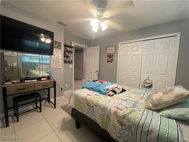 bedroom with light tile patterned floors, ceiling fan, and a closet