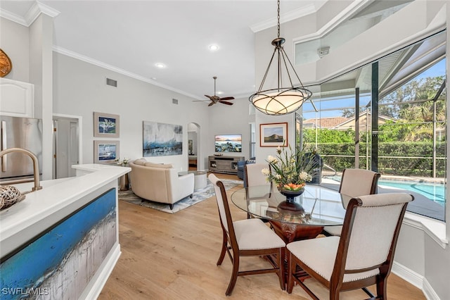 dining space featuring ornamental molding, ceiling fan, and light wood-type flooring