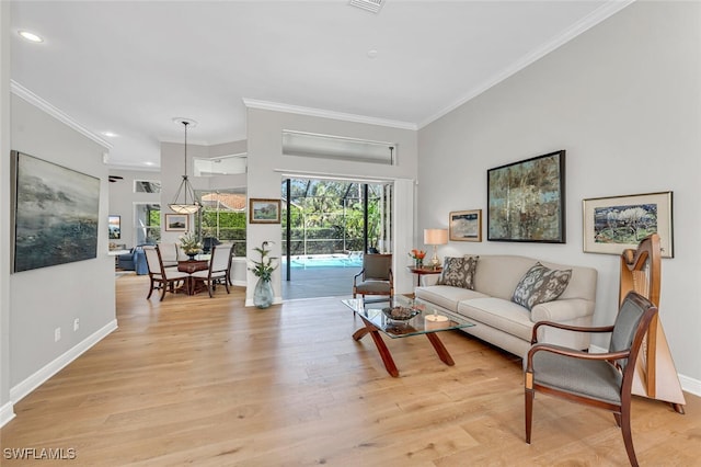 living area featuring baseboards, light wood finished floors, and ornamental molding