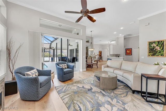 living room featuring crown molding, ceiling fan, and light hardwood / wood-style floors