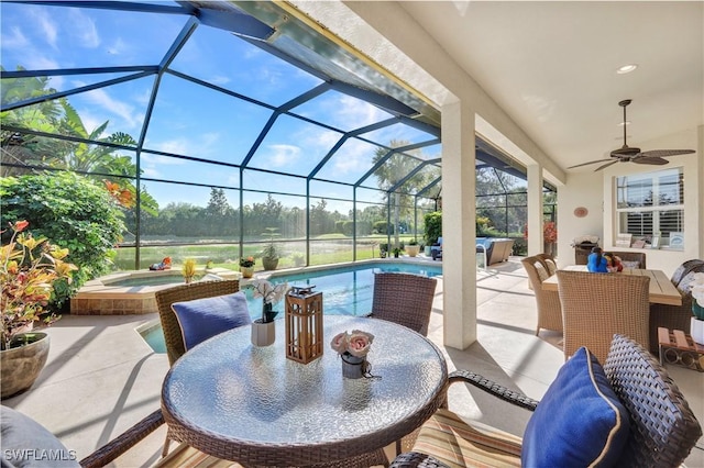 view of patio with ceiling fan, a swimming pool with hot tub, and glass enclosure