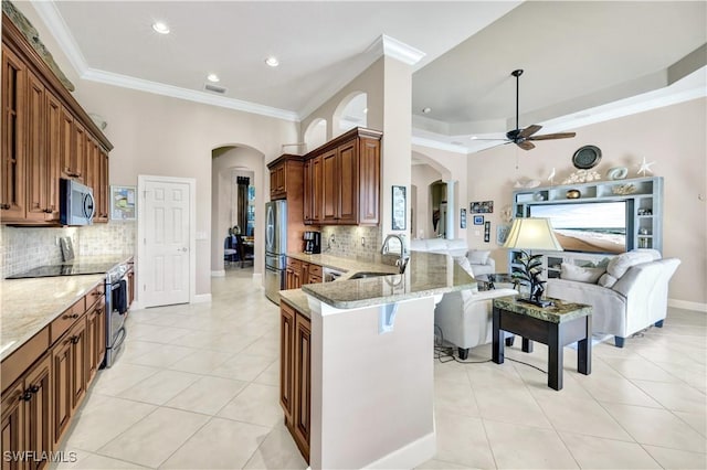 kitchen featuring light tile patterned flooring, sink, appliances with stainless steel finishes, a kitchen breakfast bar, and kitchen peninsula