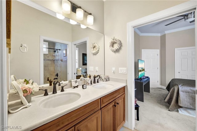 bathroom with vanity, ornamental molding, ceiling fan, and a tile shower