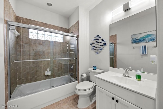 full bathroom featuring vanity, tile patterned floors, shower / bath combination with glass door, and toilet