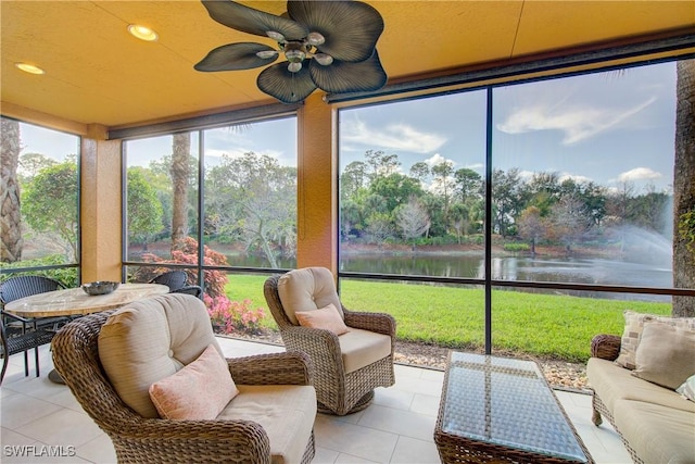 sunroom featuring ceiling fan and a water view