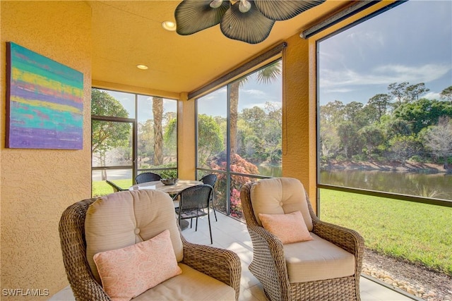 sunroom featuring a water view