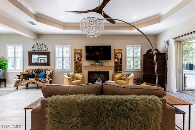 interior space featuring a fireplace, visible vents, a raised ceiling, and crown molding