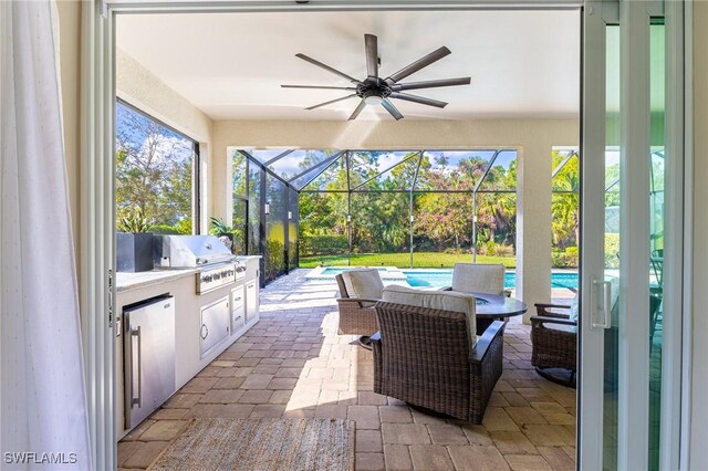 view of patio featuring a grill, area for grilling, ceiling fan, and glass enclosure