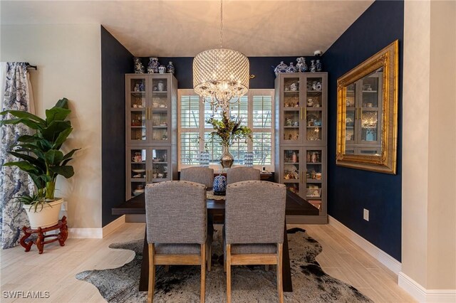 dining space featuring a notable chandelier and light wood-type flooring