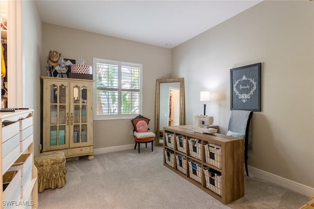 sitting room featuring light carpet and baseboards