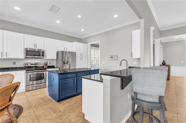 kitchen featuring stainless steel appliances, white cabinetry, a center island, and blue cabinets