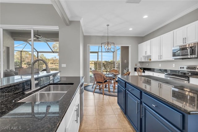 kitchen with stainless steel appliances, white cabinetry, blue cabinetry, and sink