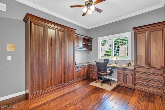 office space with dark wood-type flooring, ceiling fan, crown molding, and built in desk