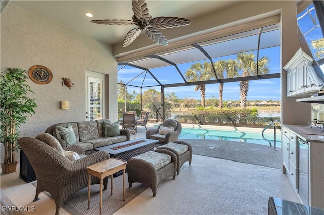 view of patio featuring an outdoor living space, a lanai, ceiling fan, and a water view