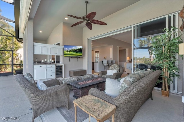 view of patio with area for grilling, an outdoor living space with a fire pit, beverage cooler, a lanai, and ceiling fan