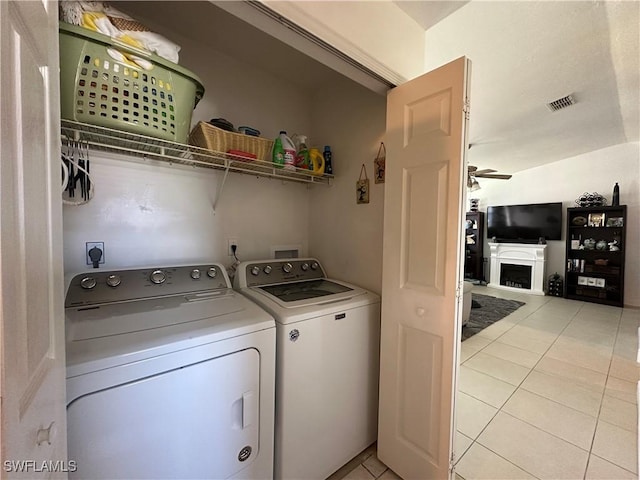 clothes washing area featuring light tile patterned floors and independent washer and dryer