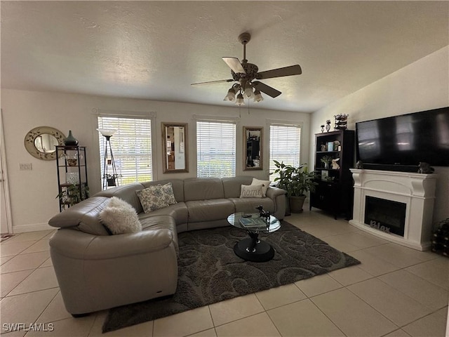 living room with light tile patterned floors, a textured ceiling, and ceiling fan