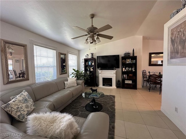 living room featuring lofted ceiling, light tile patterned floors, and ceiling fan