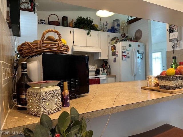 kitchen with white cabinetry and white appliances