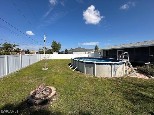 view of yard featuring a fenced in pool and an outdoor fire pit