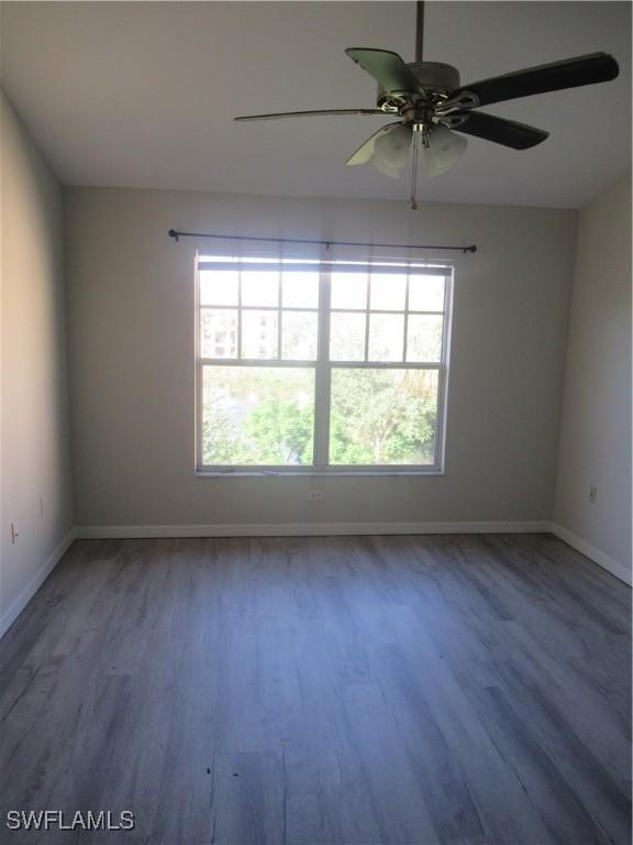 empty room with hardwood / wood-style floors and ceiling fan