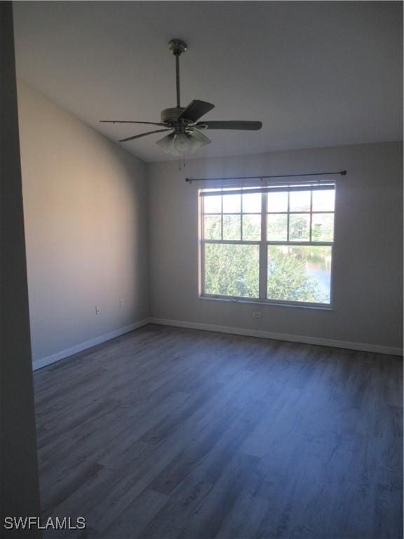 spare room featuring dark wood-type flooring and ceiling fan